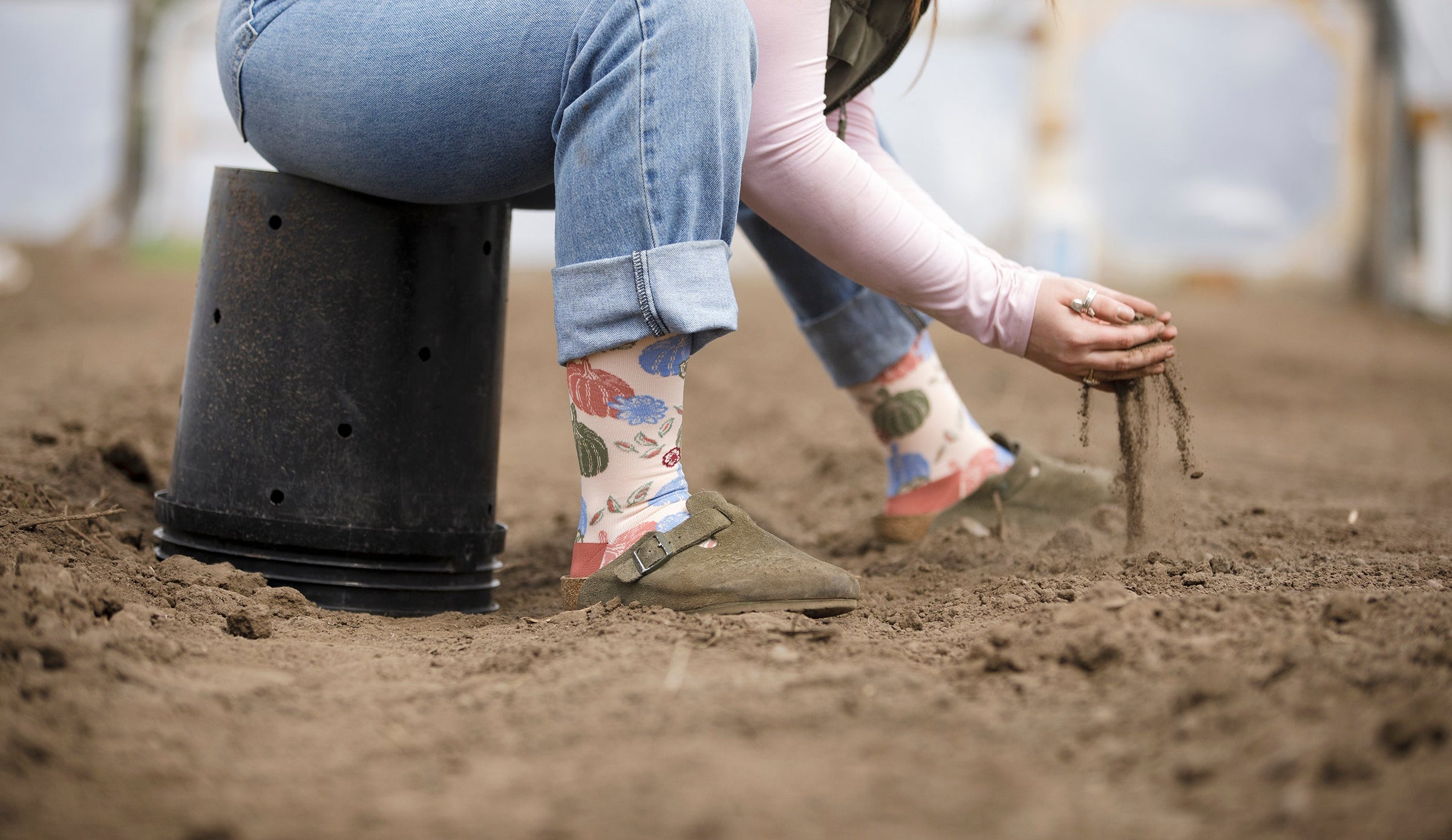 woman wearing compression socks while prepping the soil