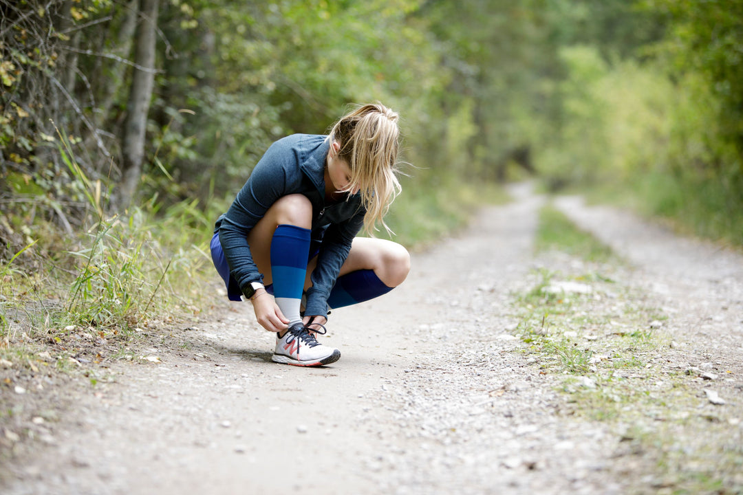 Woman adjusting compression sock for running