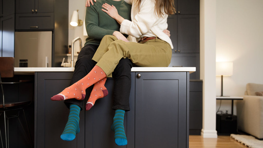 couple wearing compression socks while sitting on the side cabinet
