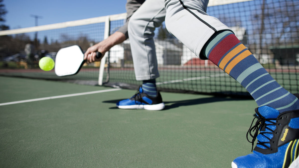a man wearing compression socks while playing pickleball