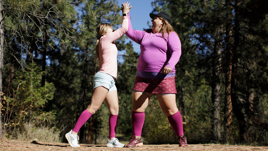 Two women high fiving after completing a hike on VIM & VIGR Compression Socks