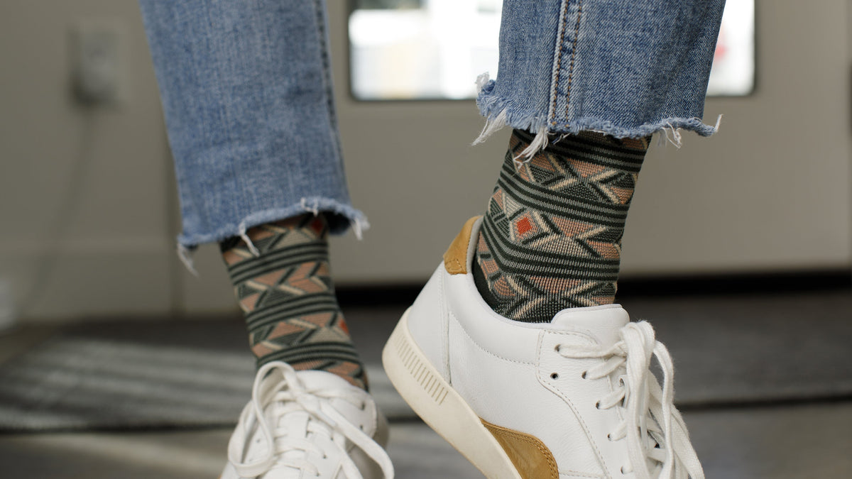 a man on jeans and sneakers wearing compression socks inside