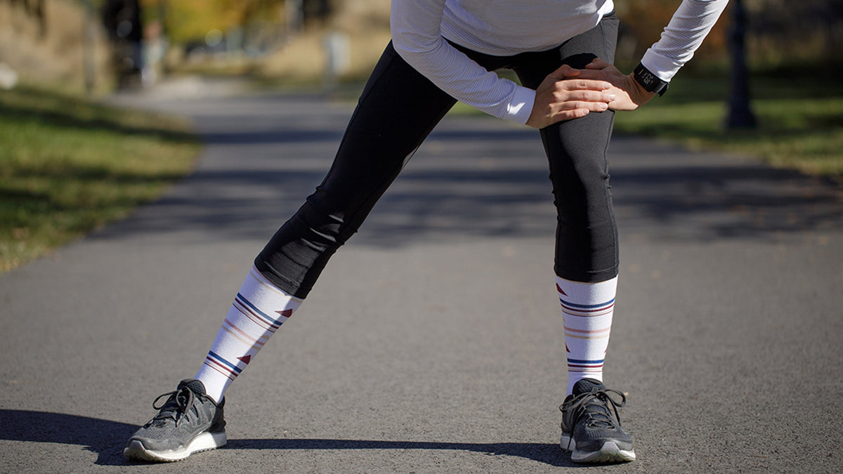 woman in compression leggings while stretching.