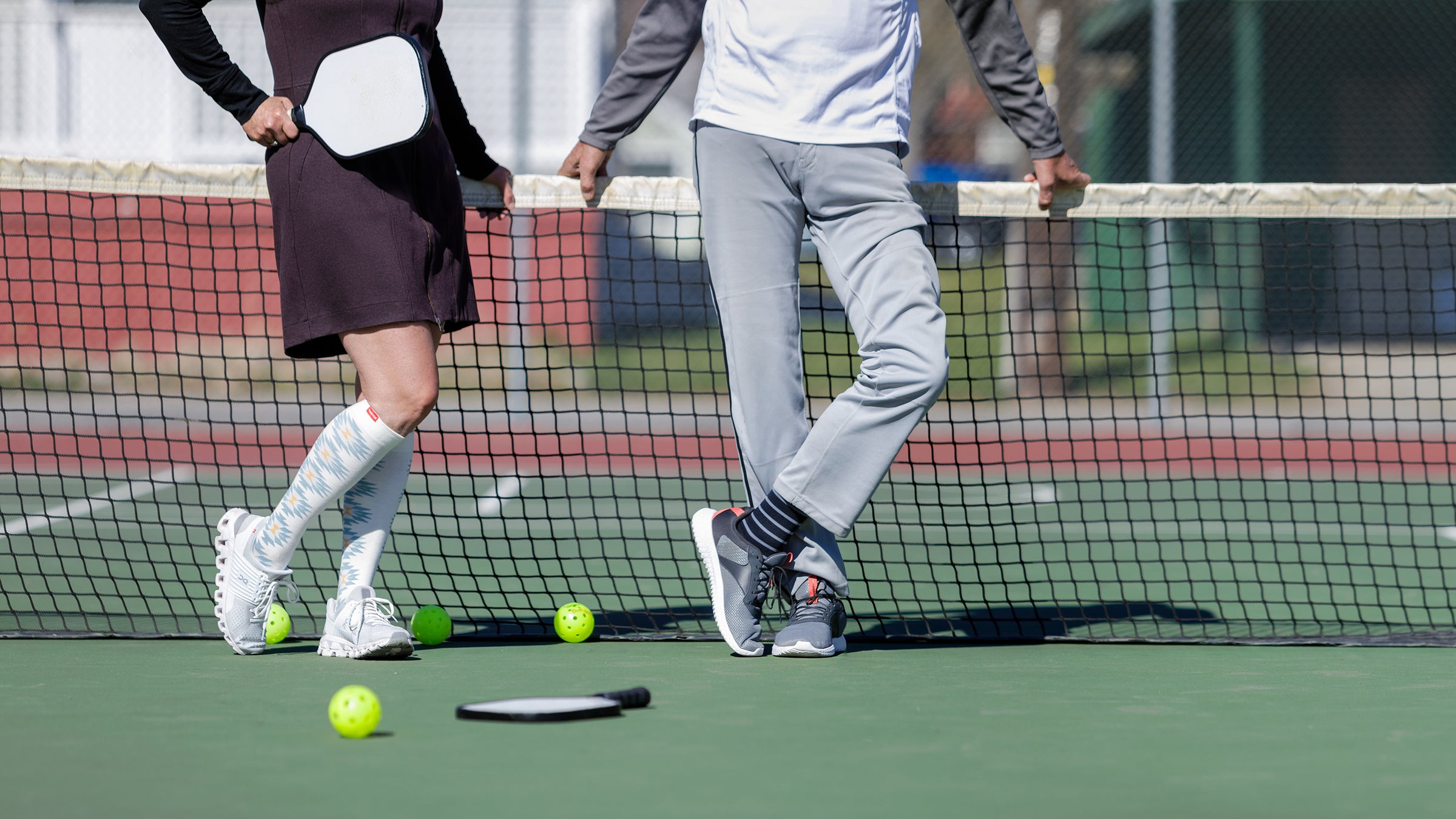 man and woman wearing compression socks on a pickle ball court