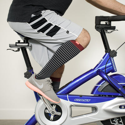 man pedaling wearing his 30-40 mmHg: Little Stripe Black & Grey square (Nylon) Compression Socks